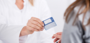 jeune médecin souriante donnant une carte de tiers payant ou carte mutuelle à un patient