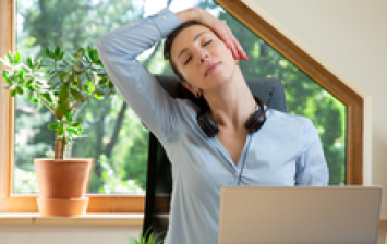 jeune femme qui fait de l’exercice et s’étire devant son ordinateur portable à la maison, en tété travail, pour préserver son capital santé.