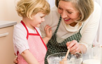 femme senior avec sa petite fille prepare un plat equilibre