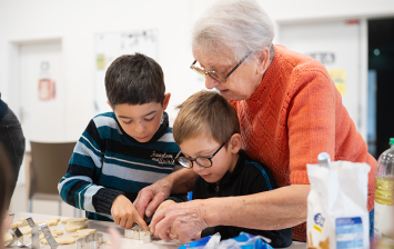 Femme en maison de retraite qui passe du temps avec deux enfants d’école primaire 