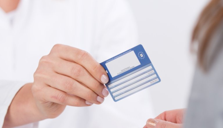 jeune médecin souriante donnant une carte de tiers payant ou carte mutuelle à un patient