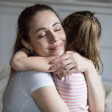 Jeune femme tenant dans ses bras une enfant 