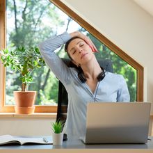 jeune femme qui fait de l’exercice et s’étire devant son ordinateur portable à la maison, en tété travail, pour préserver son capital santé.