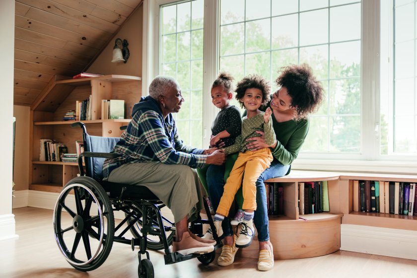 femme handicapée souriante accompagnée d’aidants familiaux