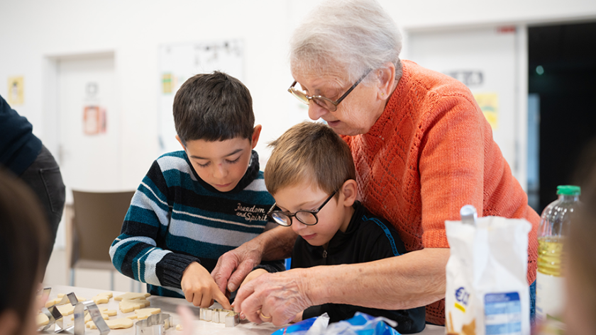 Femme en maison de retraite qui passe du temps avec deux enfants d’école primaire 