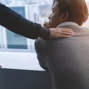 jeune homme assis encouragé par un autre homme, concept de solidarité au travail